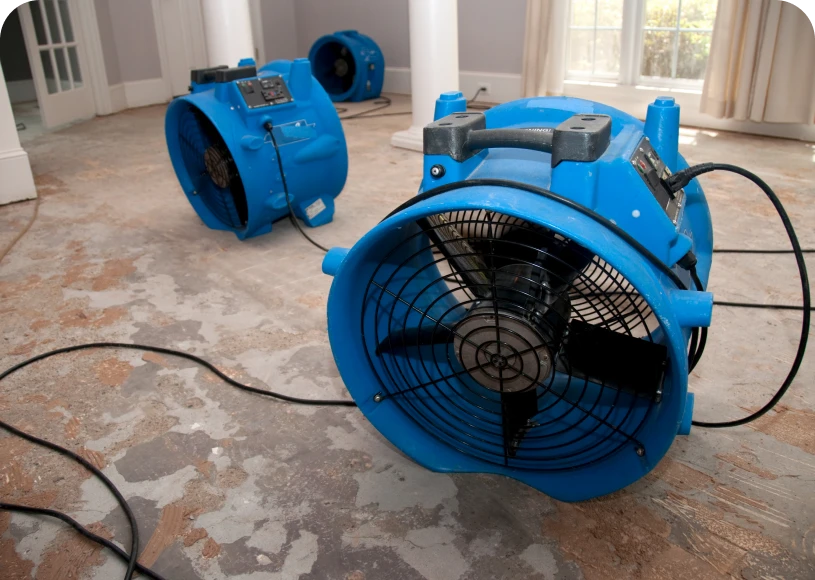 Blue industrial fans on damaged floor.