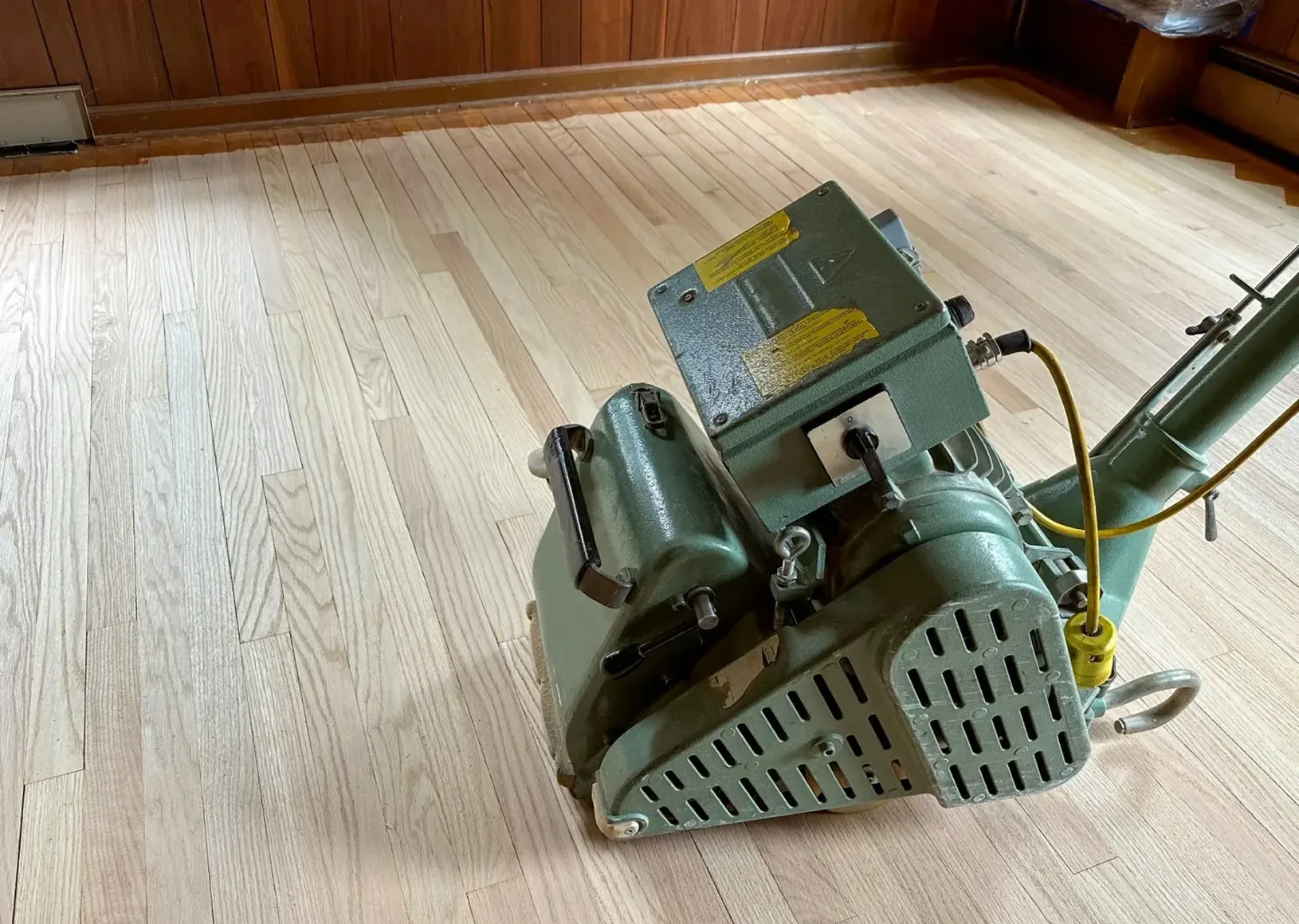 Hardwood floor sander on unfinished planks