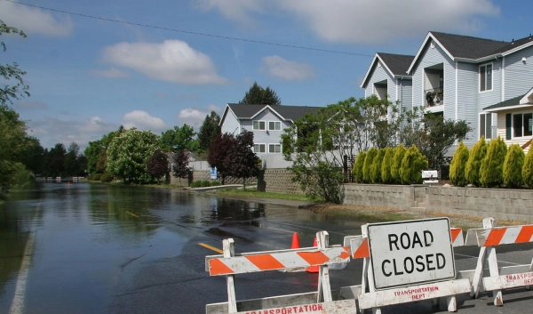 Flooded street with "Road Closed" sign.