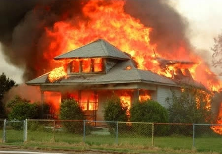 House engulfed in flames, heavy smoke rising.