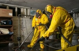 Workers in hazmat suits cleaning basement.