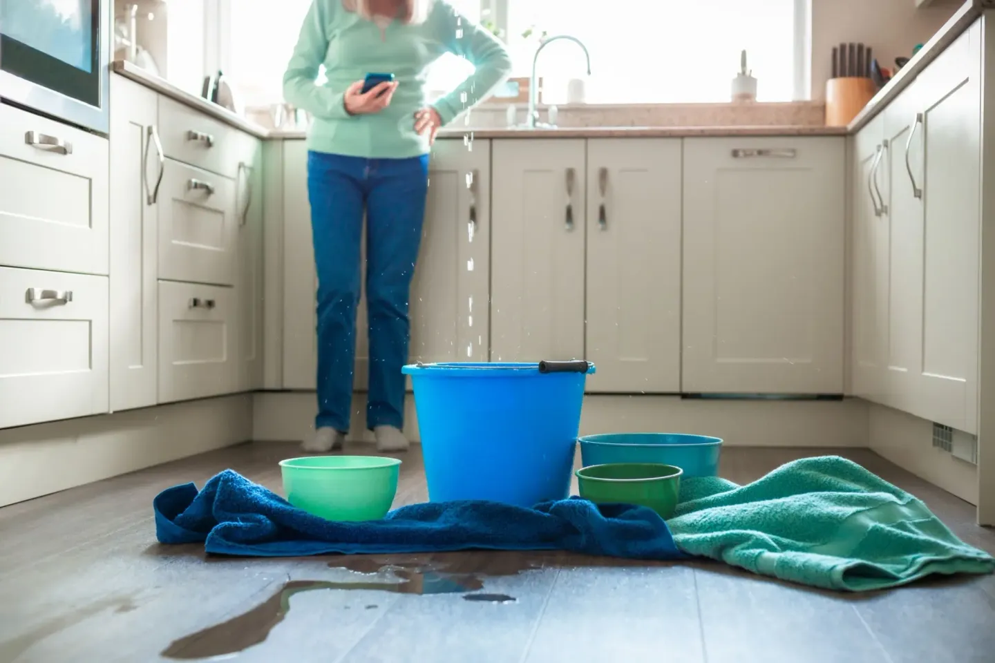 Homeowner dealing with kitchen water damage